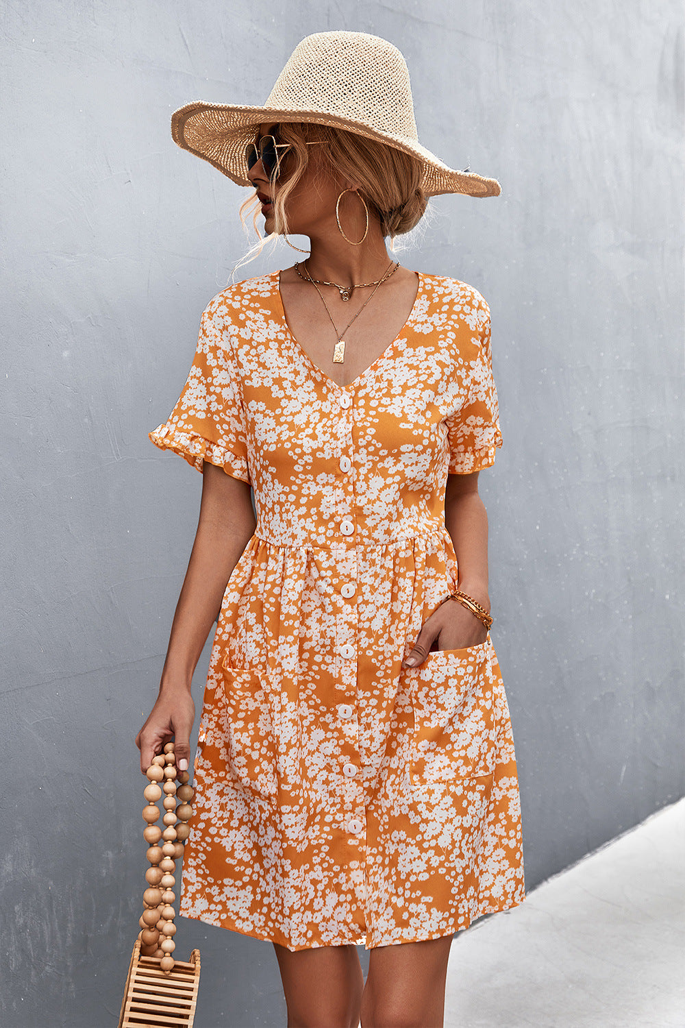 Orange floral printed button-front dress with V-neck, short sleeves, and patch pockets.