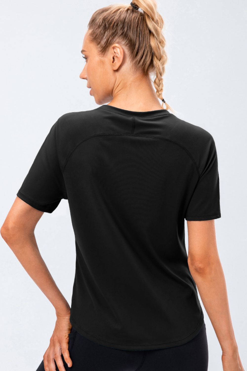 Black active tee with round neck and raglan sleeves, back view