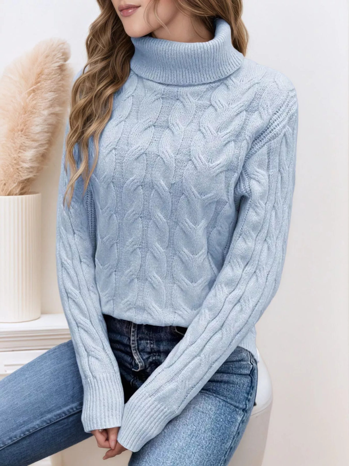 Light blue cable knit turtleneck sweater with long sleeves and chunky cable texture