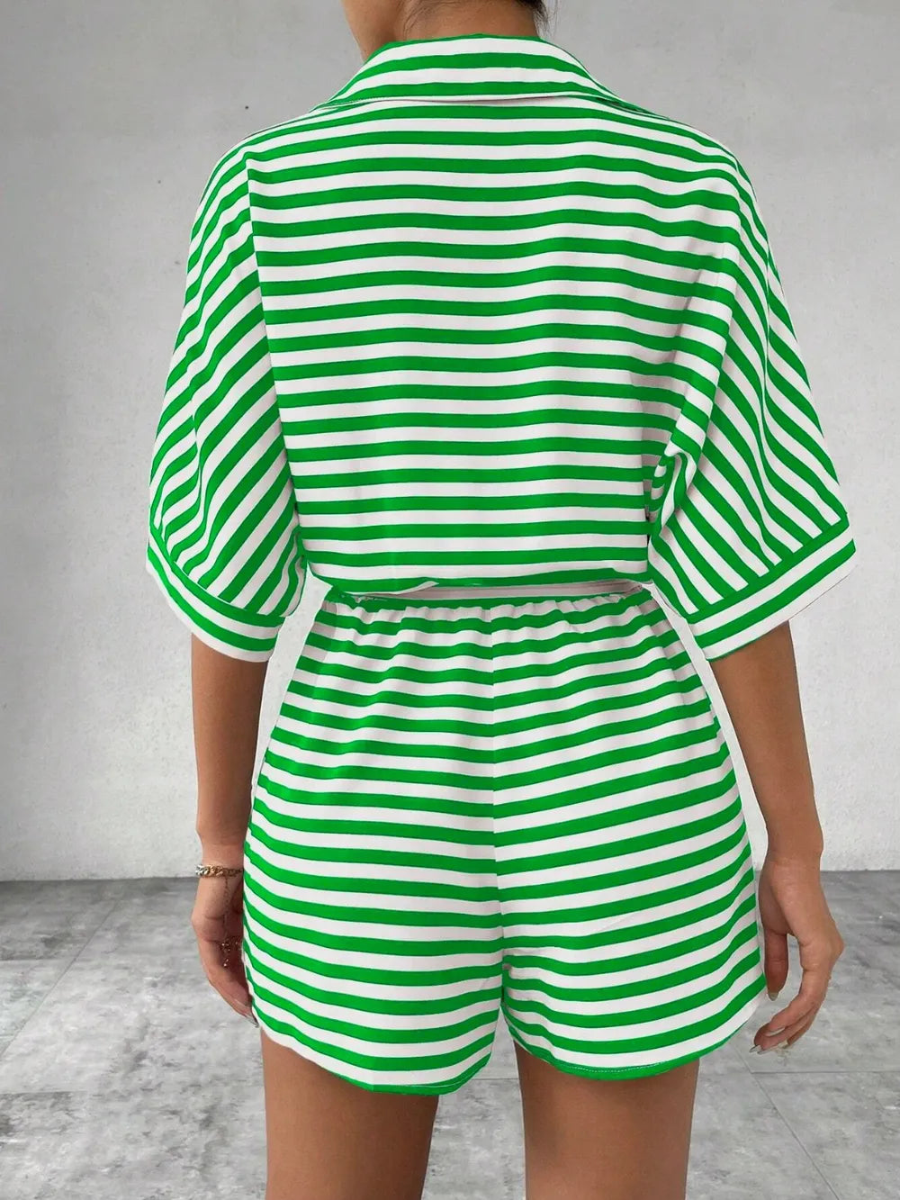 Green-and-white striped romper with tie waist and half-button top; back view
