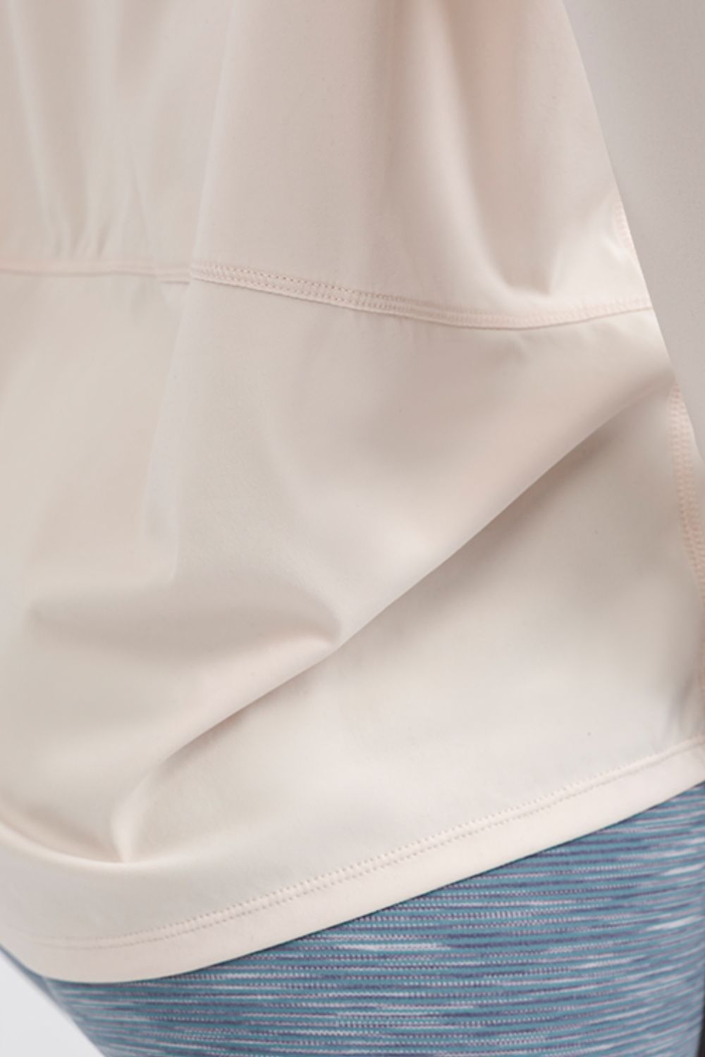 Cream loose fit active top, curved back hem with stitched seam