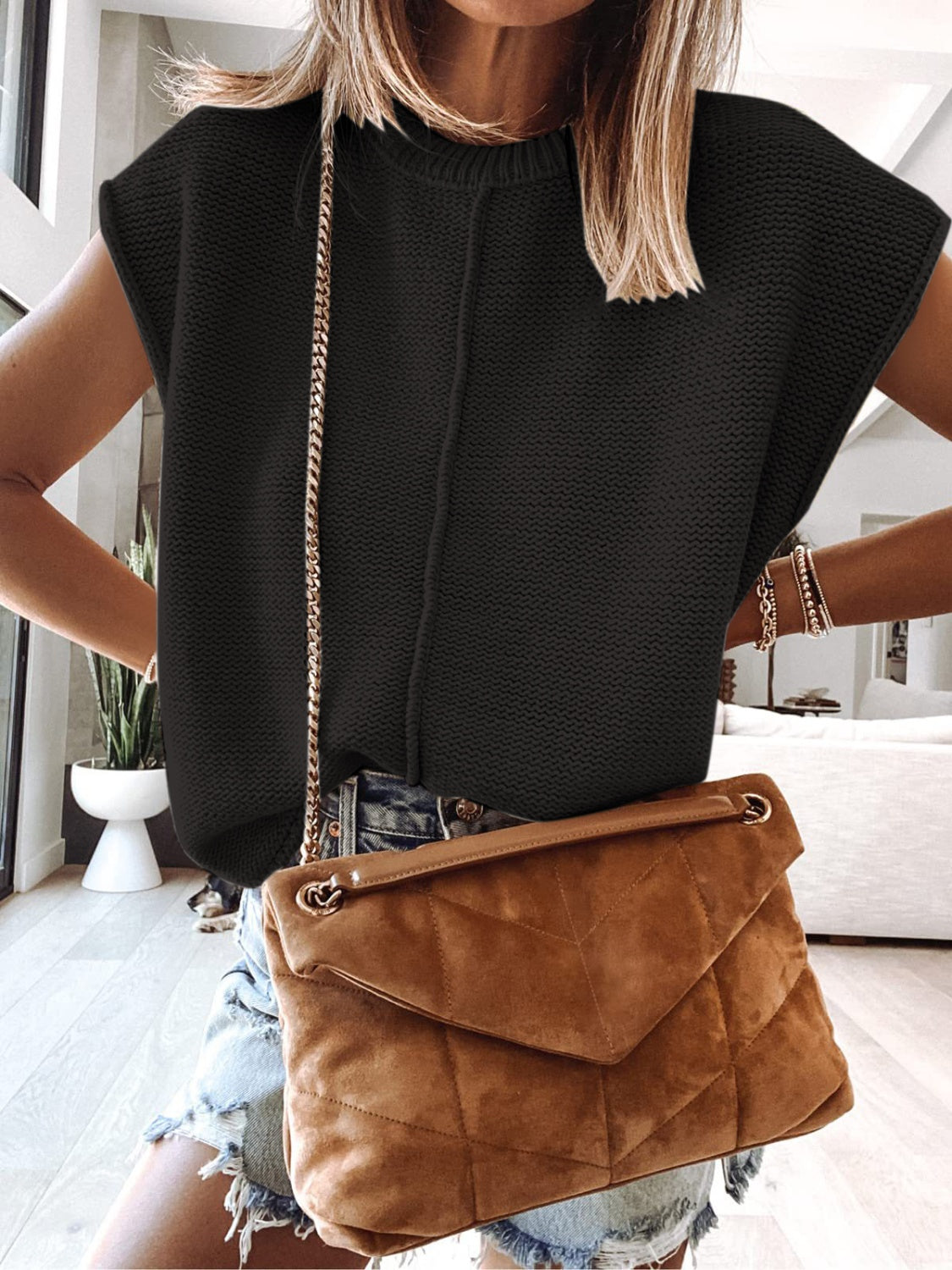 Cap-sleeve sweater vest in black knit with a ribbed crew neckline and central vertical seam