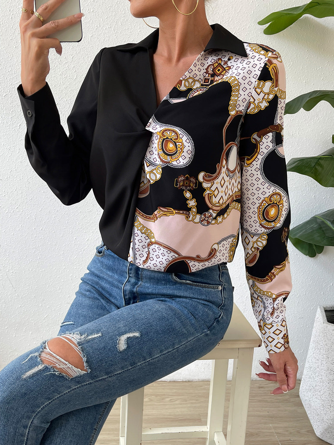 Black twist-front collared blouse with patterned long sleeve panel and wrap front