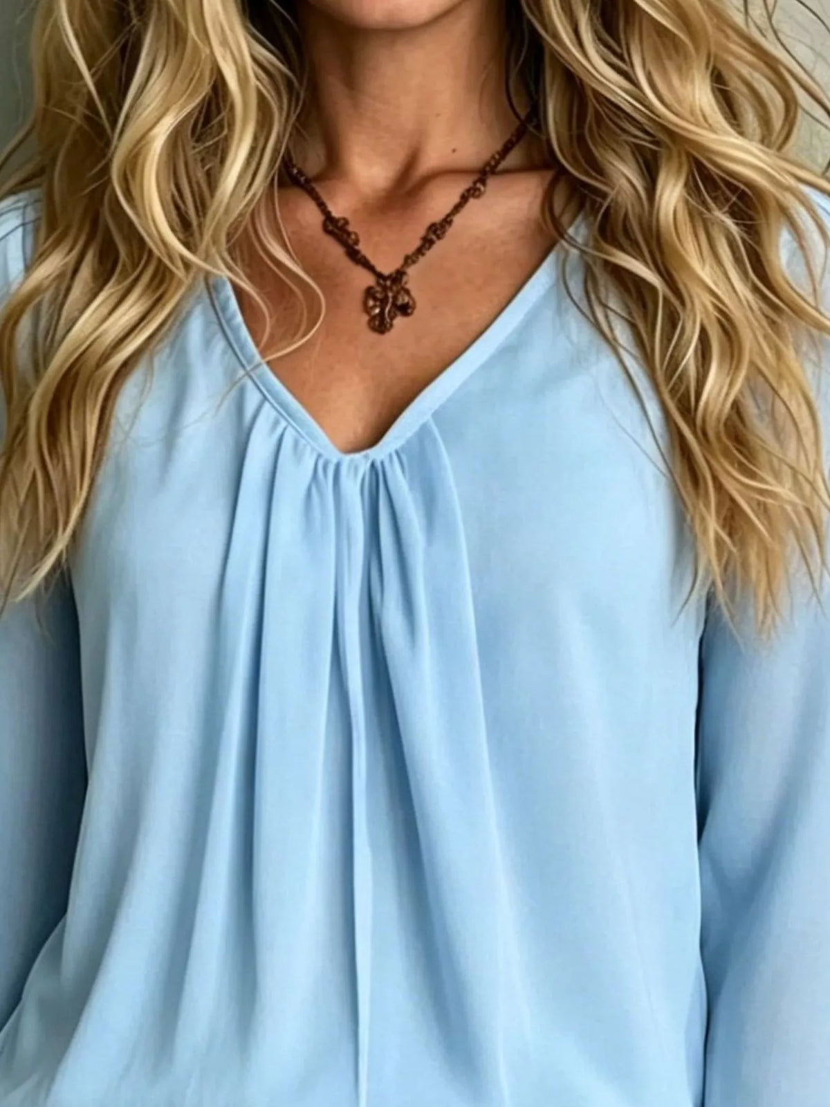 Light blue polyester blouse with V-neck and gathered front, flounce sleeve cuffs