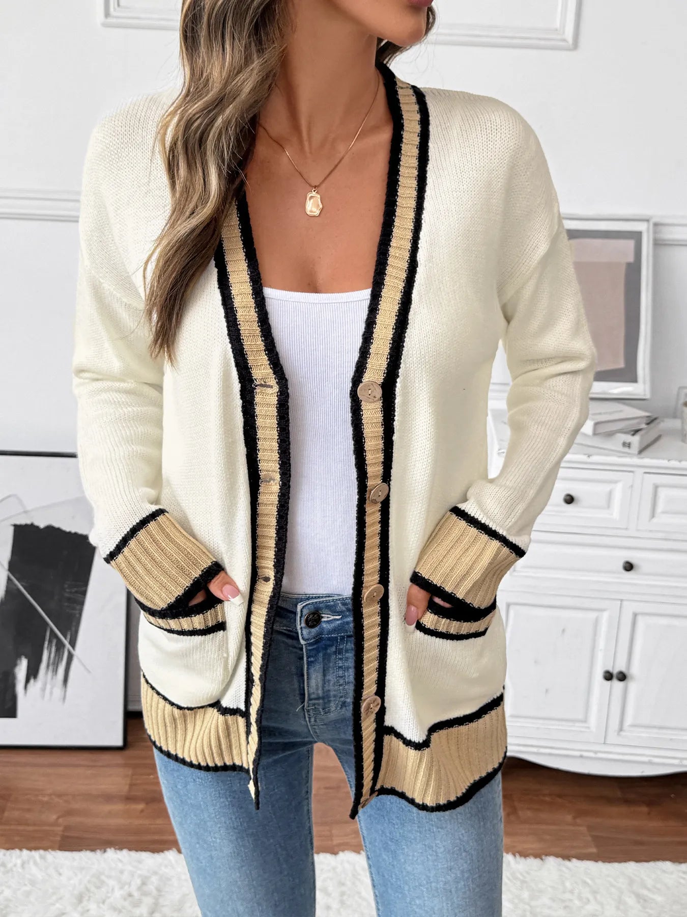 Cream knit cardigan with black and tan striped trim, button front, ribbed cuffs