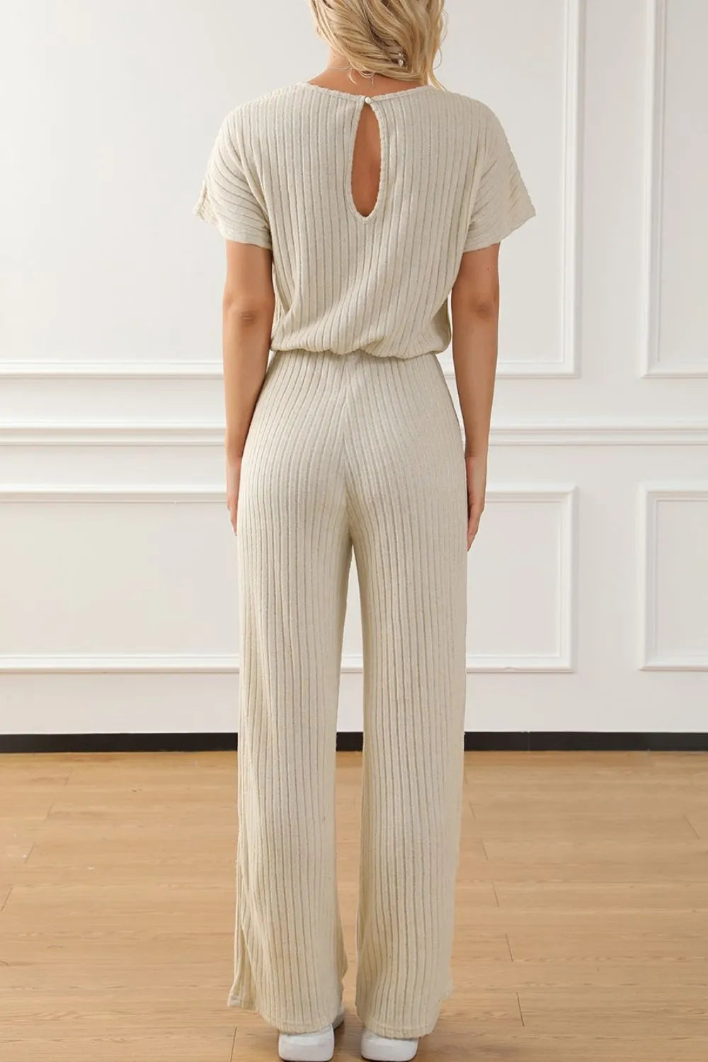Beige ribbed knit wide-leg jumpsuit back view with keyhole cutout and wide legs