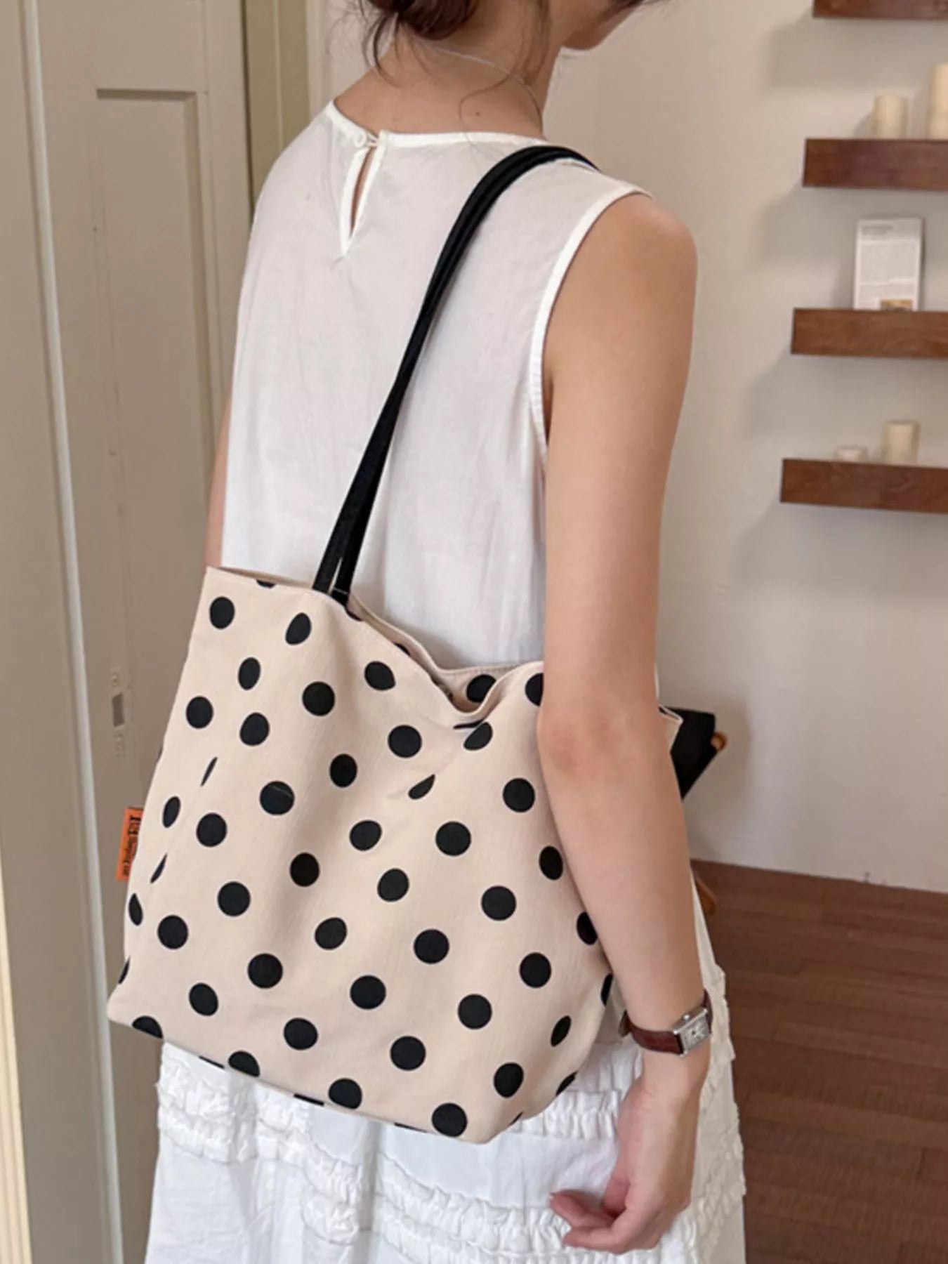 Cream polka dot medium tote with black dots and long black handles, back view