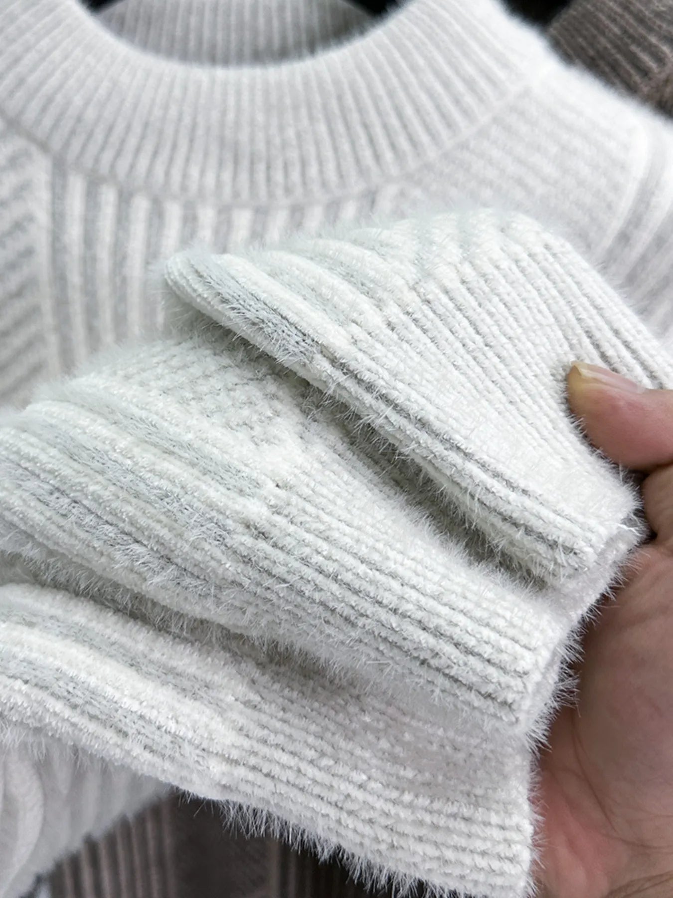 Men's off-white knit sweater sleeve cuff, ribbed texture with soft fuzzy finish
