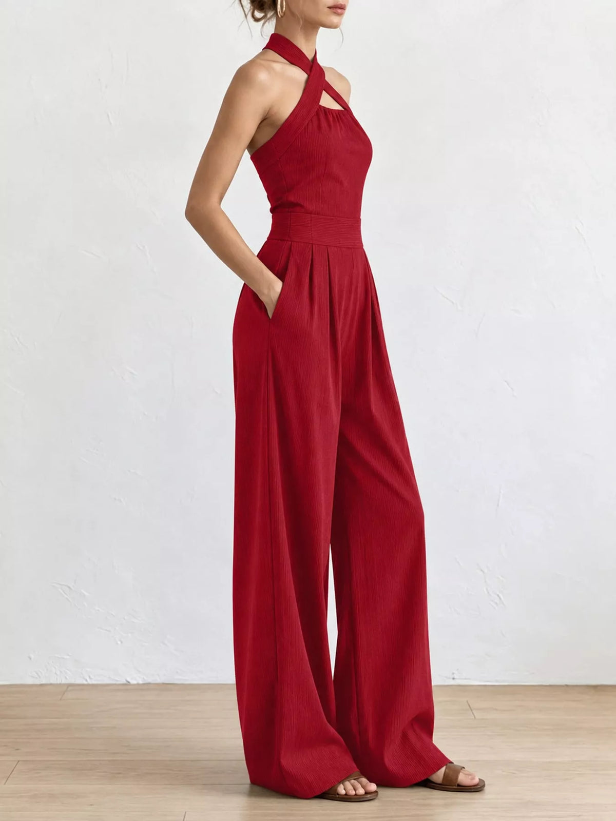 Red halter jumpsuit with high waist seam and wide-leg silhouette