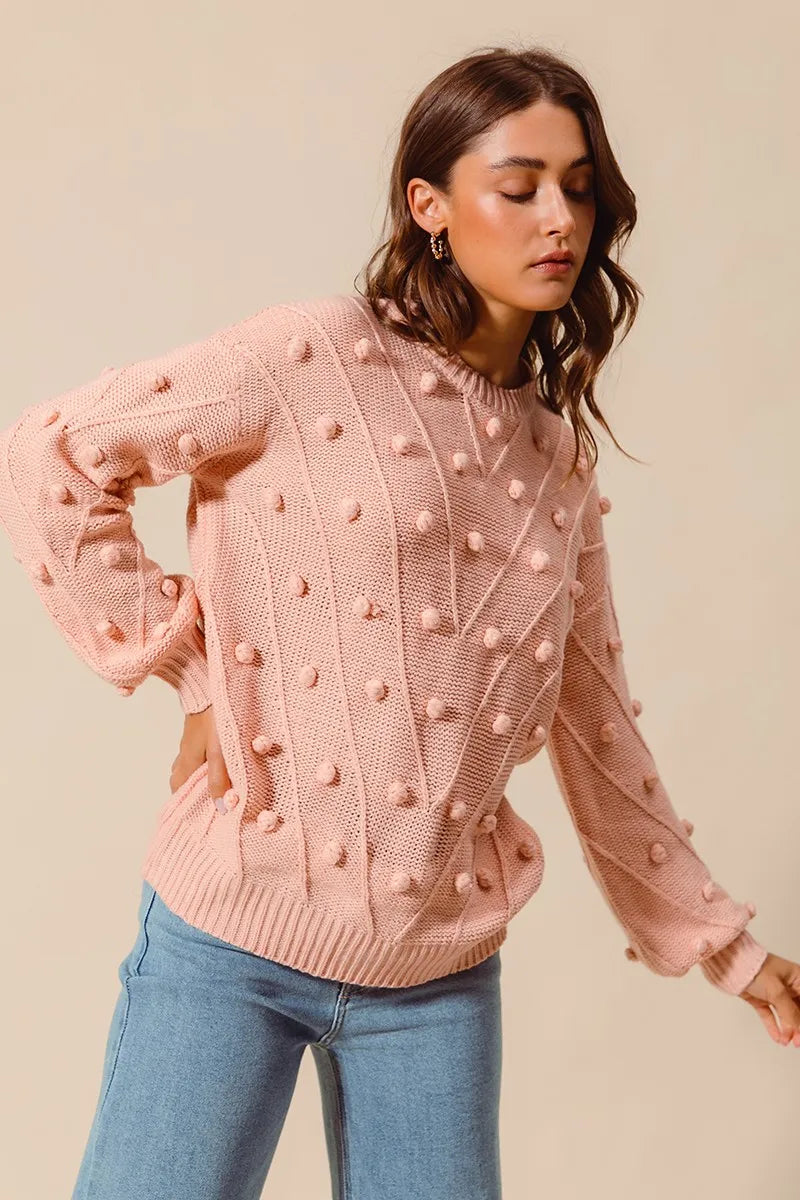 Blush pom-pom knit crewneck sweater with long sleeves and ribbed cuffs