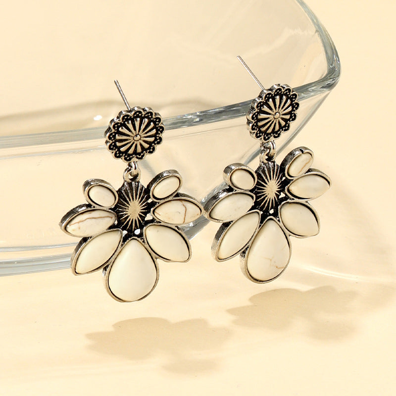 Silver-tone flower earrings, dangling teardrop petals with textured center burst and hook