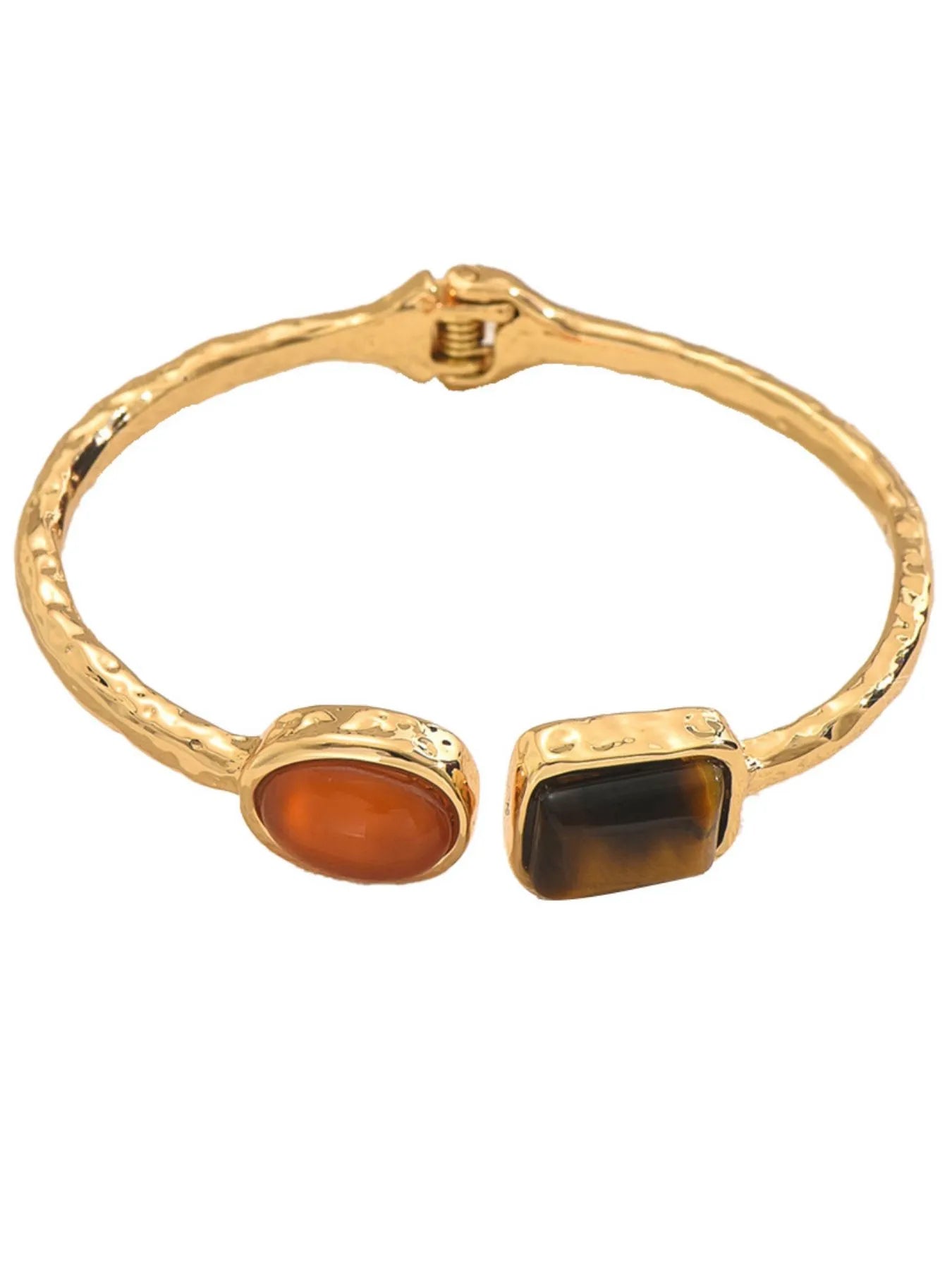 Gold tone geometric open bracelet with orange oval and dark square insets, front view