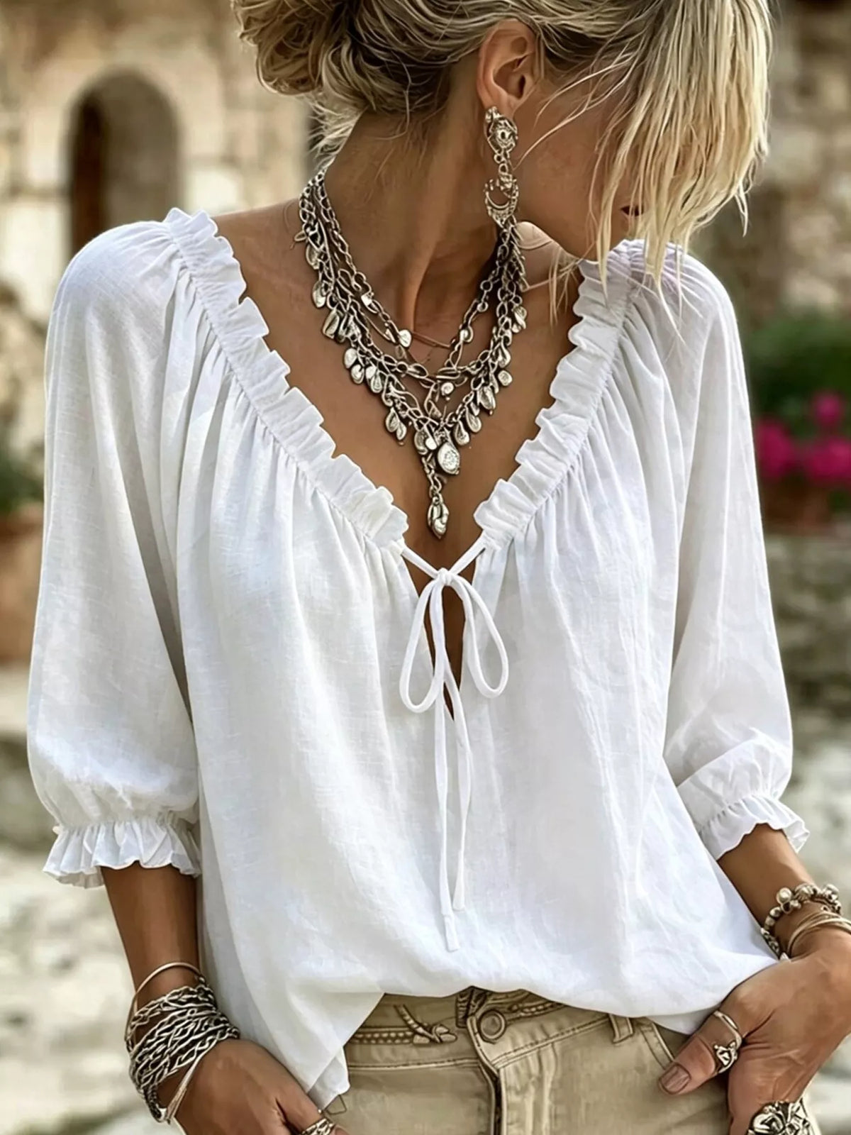 White tie-neck blouse with frilled V neckline and three-quarter puff sleeves