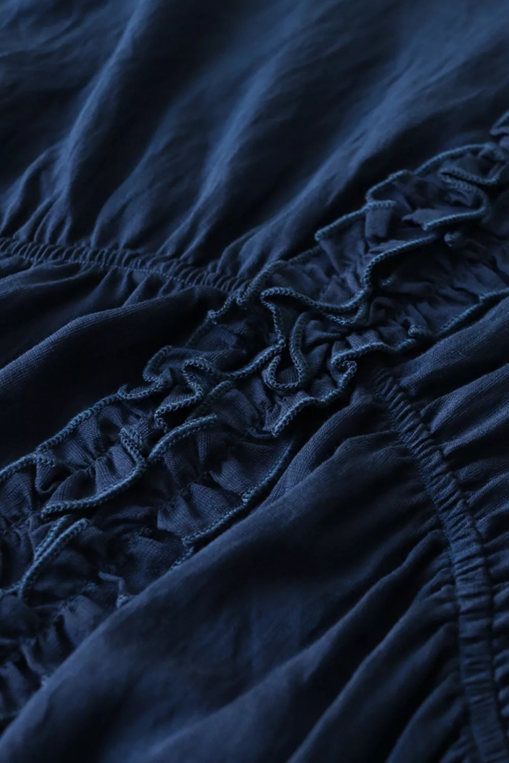 Ruffle Hem Tie Neck Blouse in navy fabric; features gathered elastic and ruffle detailing