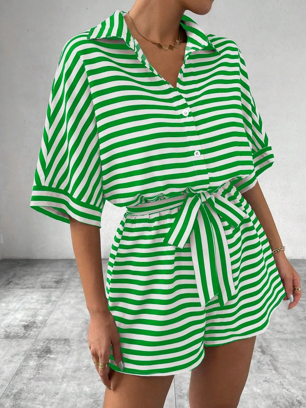 Green-and-white striped tie-waist romper with half-button V-neck and tied waist