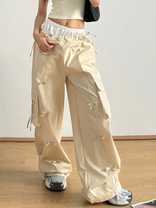 Tan elastic-waist cargo pants with side cargo pockets and dangling tie straps