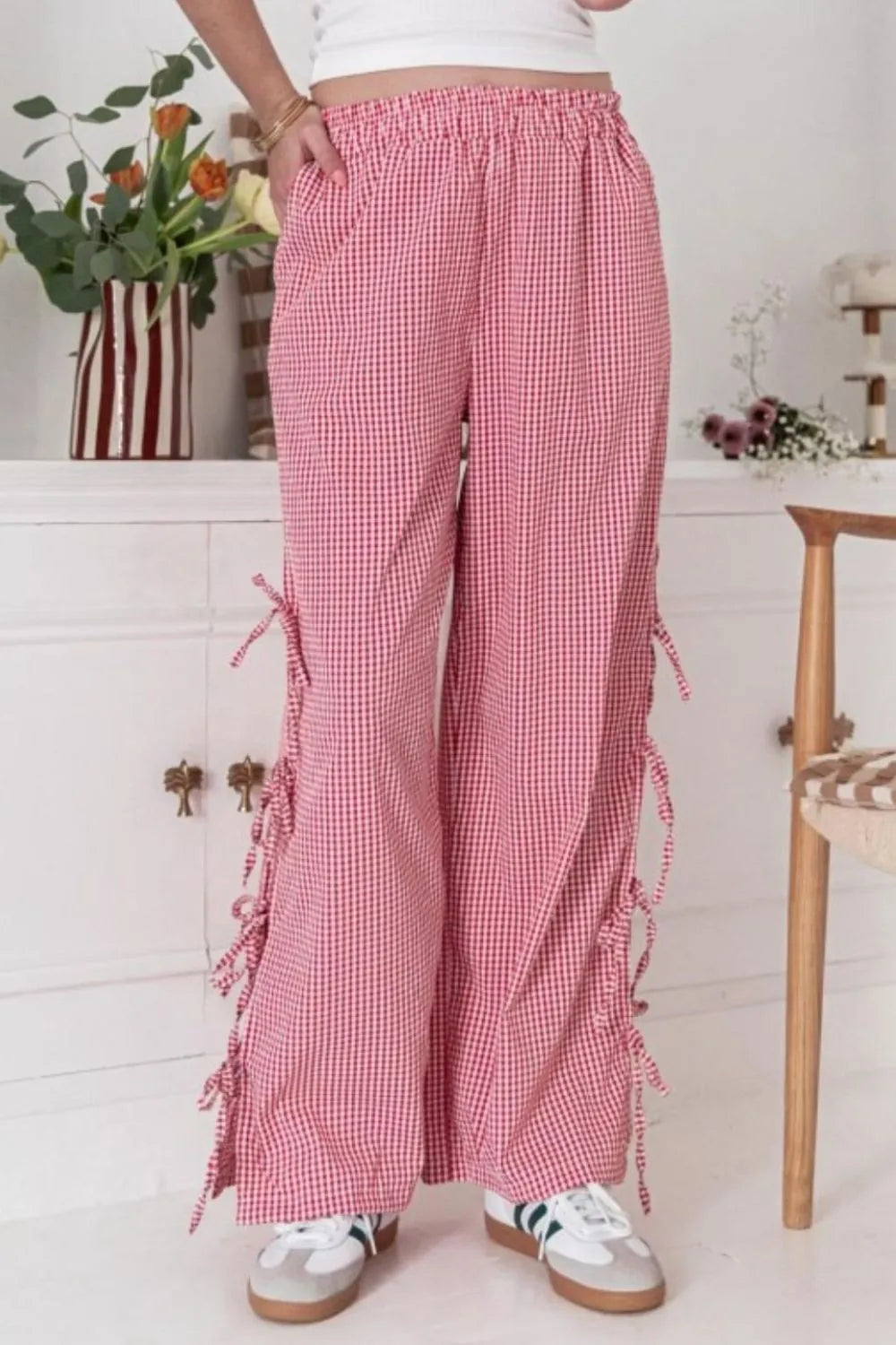 Pink gingham wide-leg pants with elastic waistband and tied side pocket details