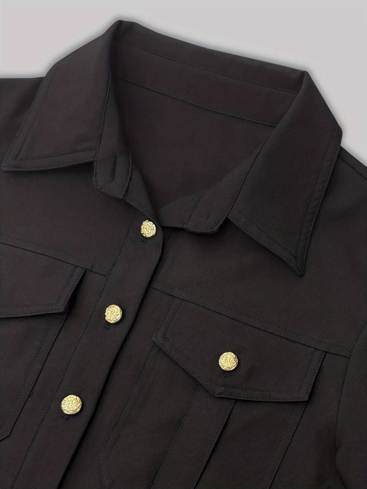 Black button-front midi dress with flap collar, chest pockets, and gold-tone buttons