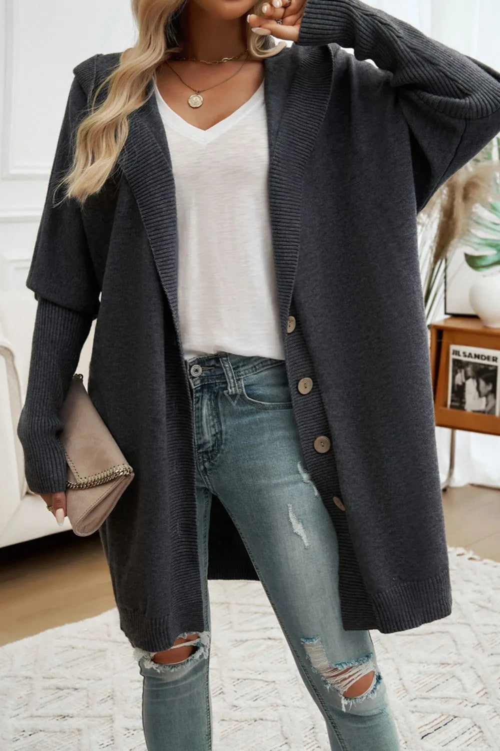 Dark gray hooded long cardigan with button front and ribbed knit, worn over jeans.