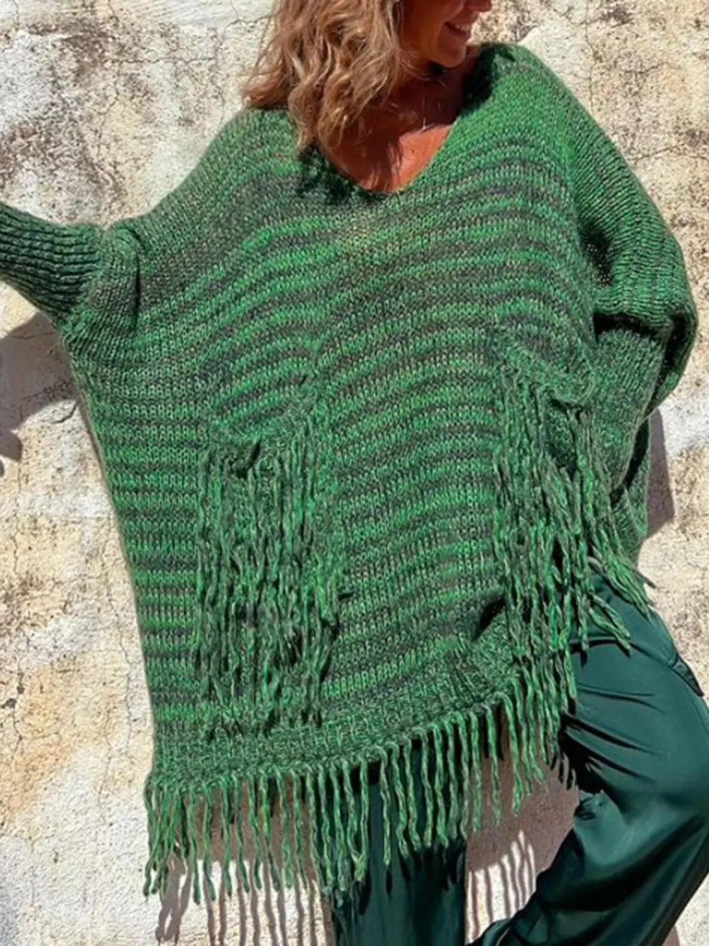 Dark green long-sleeve sweater with braided fringe pocket accents and textured knit.