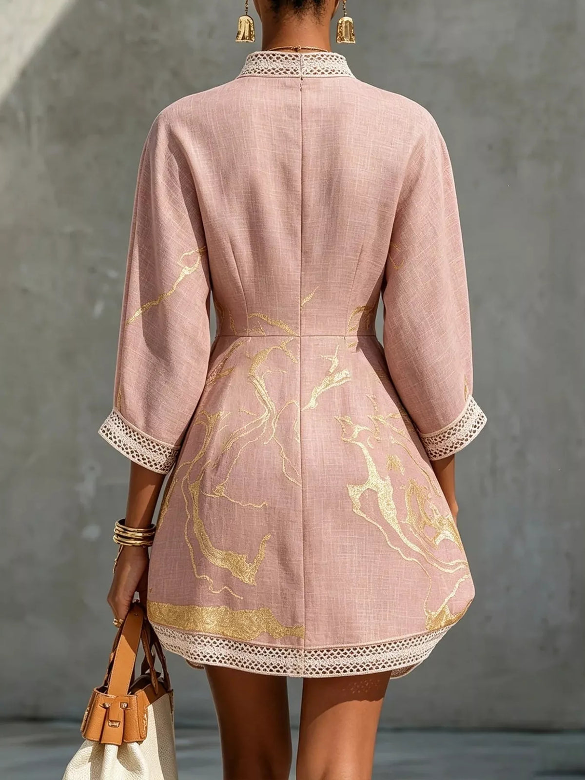 Pink relaxed-fit mini dress back view with vertical seam, gold print, and lace-trim sleeves