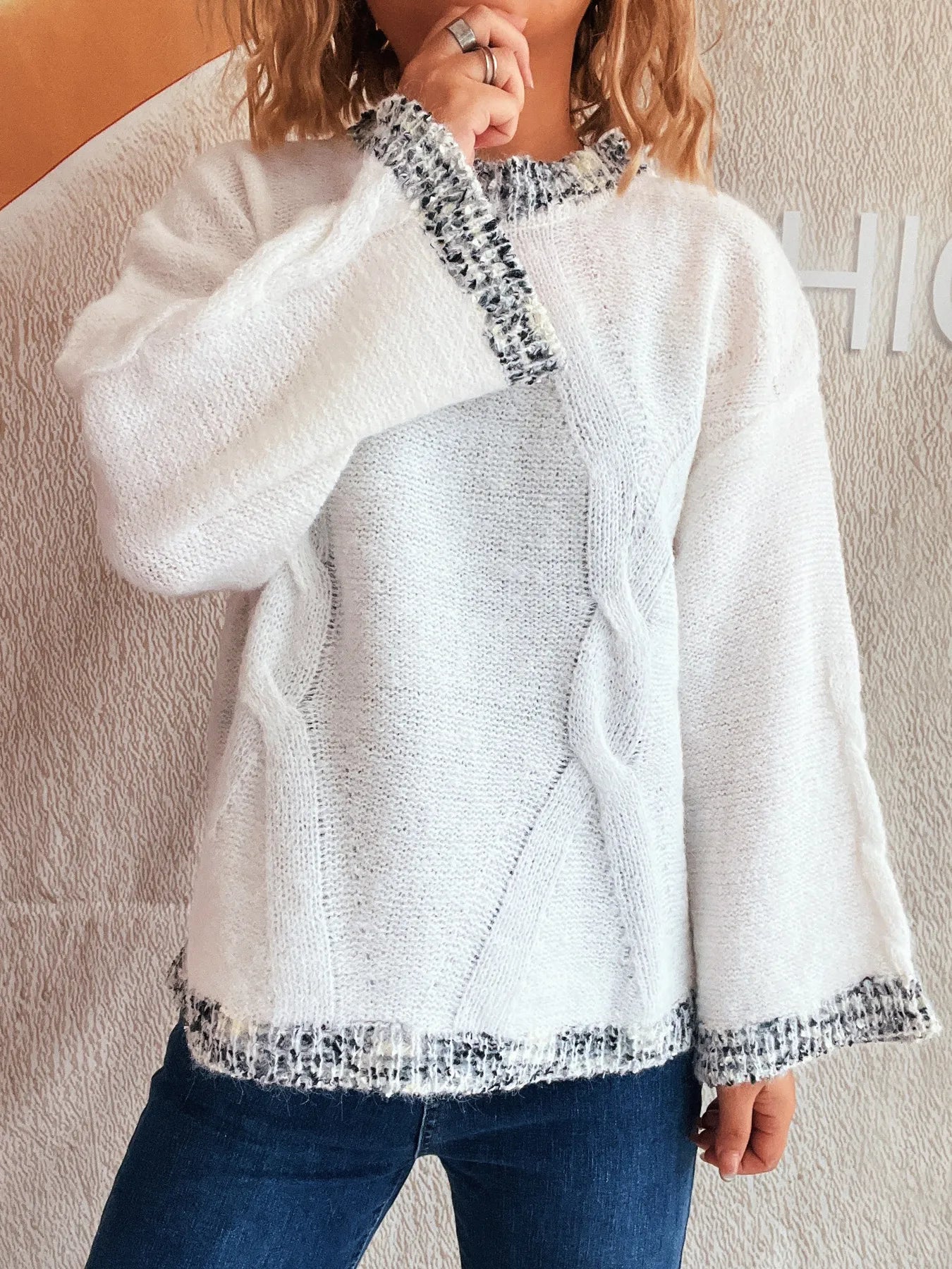 White round-neck sweater with contrast knit trim at collar, cuffs, and hem