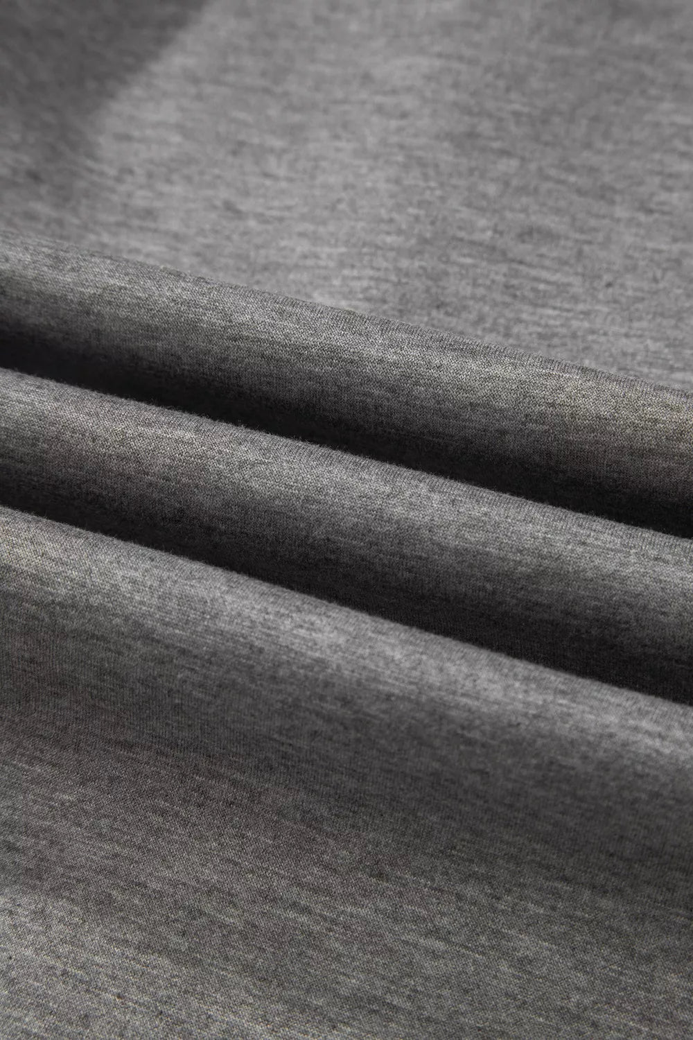 Dark gray heather knit fabric close-up with visible weave and seam