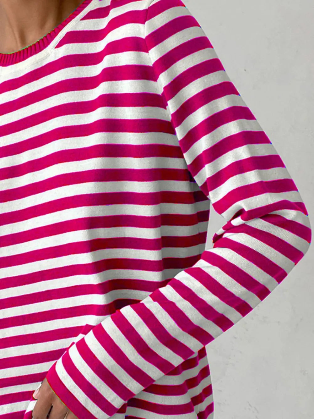 Striped long-sleeve sweater close-up in pink and white stripes.